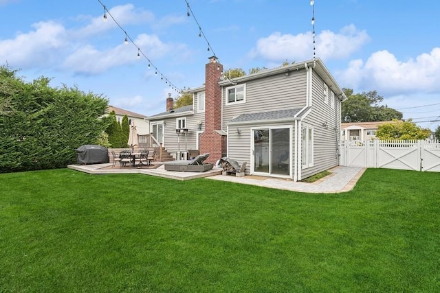 back of house featuring a chimney, a lawn, a gate, a patio area, and fence