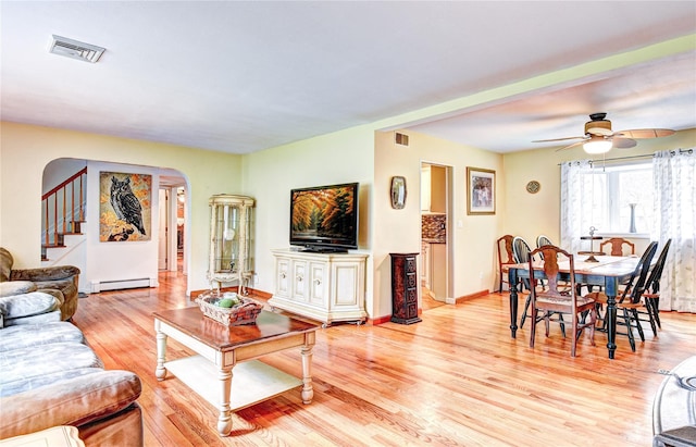 8 Lucky Ln, Washingtonville, NY 10992 - living area with a baseboard radiator, arched walkways, light wood-type flooring, stairs, and ceiling fan