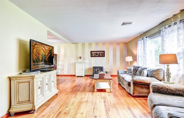 8 Lucky Ln, Washingtonville, NY 10992 - living room featuring a wood stove, light wood-style floors, wallpapered walls, and baseboards