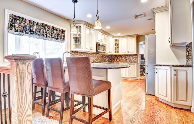 8 Lucky Ln, Washingtonville, NY 10992 - kitchen featuring appliances with stainless steel finishes, a breakfast bar area, glass insert cabinets, decorative backsplash, and pendant lighting