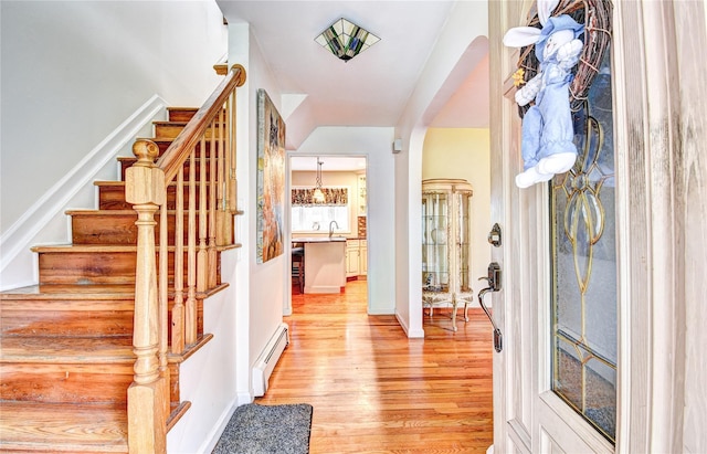 8 Lucky Ln, Washingtonville, NY 10992 - foyer with a baseboard heating unit, light wood-style flooring, stairs, and arched walkways