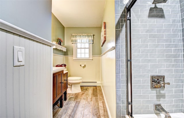 8 Lucky Ln, Washingtonville, NY 10992 - bathroom featuring a baseboard radiator, hardwood / wood-style flooring, a wainscoted wall, toilet, and a tile shower