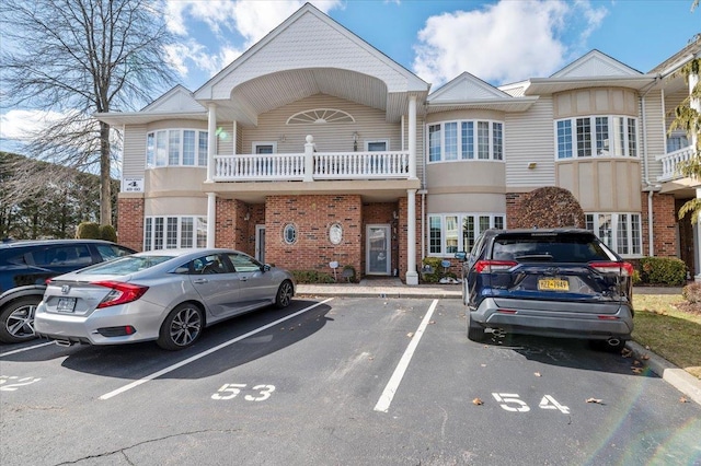 view of front of home with uncovered parking and brick siding