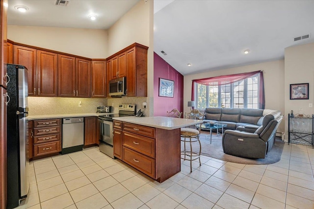 kitchen with visible vents, light countertops, appliances with stainless steel finishes, open floor plan, and a peninsula