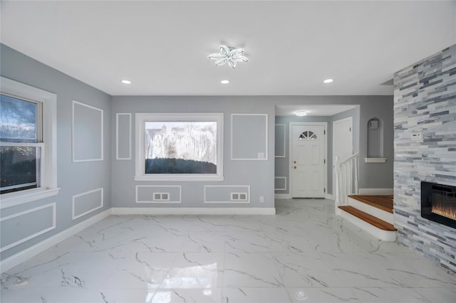 unfurnished living room with a tiled fireplace