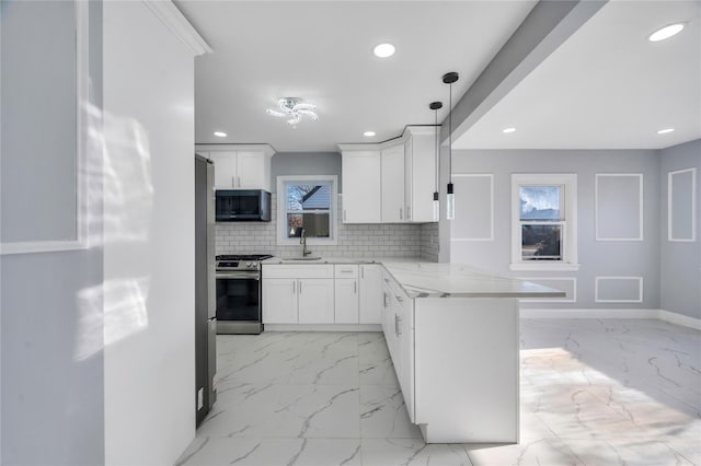 kitchen featuring white cabinetry, kitchen peninsula, gas stove, and pendant lighting