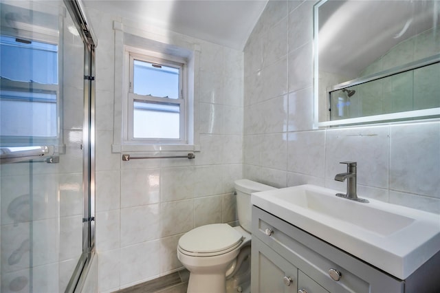 bathroom with tile walls, vanity, an enclosed shower, vaulted ceiling, and toilet