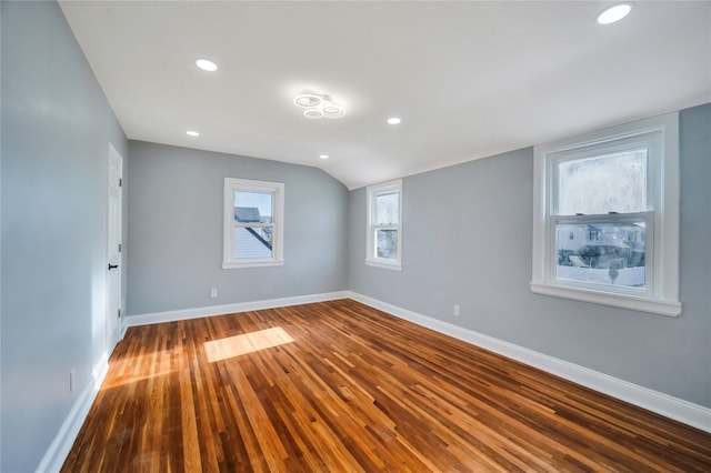 empty room featuring hardwood / wood-style floors and vaulted ceiling