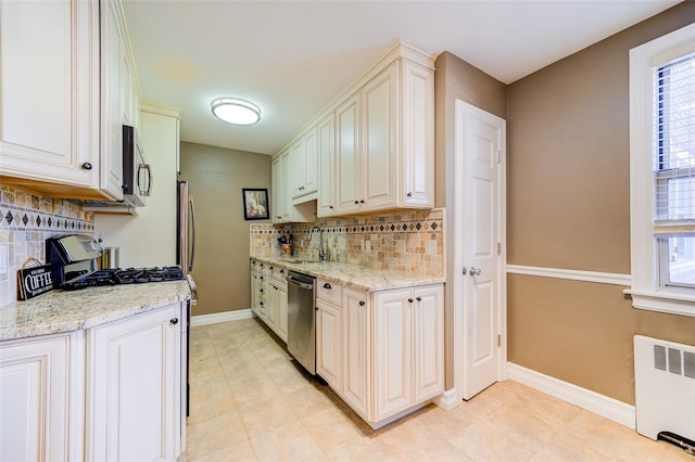 15 Bryant Cres Unit 1K, White Plains, NY 10605 - kitchen featuring sink, radiator, stainless steel appliances, and light stone counters