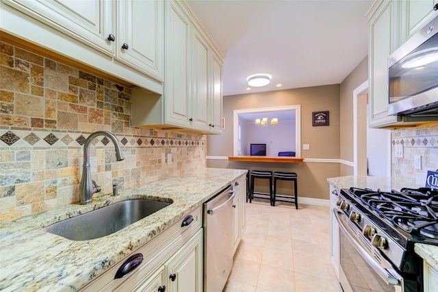 15 Bryant Cres Unit 1K, White Plains, NY 10605 - kitchen featuring stainless steel appliances, cream cabinetry, light stone countertops, sink, and light tile patterned floors