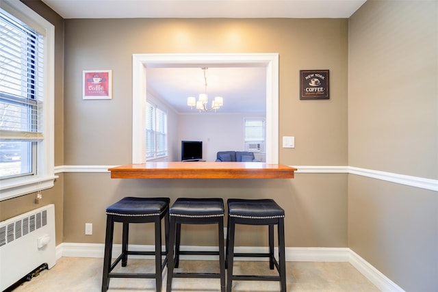15 Bryant Cres Unit 1K, White Plains, NY 10605 - kitchen with an inviting chandelier, a kitchen bar, radiator, and decorative light fixtures