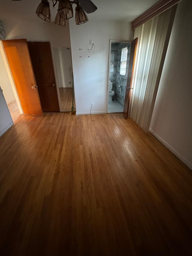 158-24 81st St, Howard Beach, NY 11414 - unfurnished bedroom featuring baseboards, ensuite bath, and wood finished floors