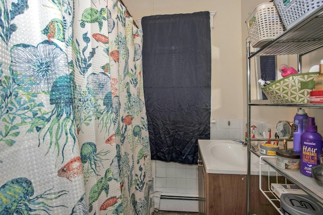 full bath featuring a baseboard radiator, vanity, and tile walls