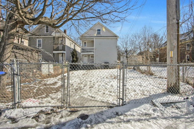 snowy yard featuring fence and a gate