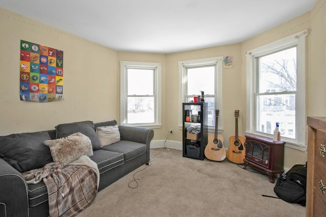 living area with baseboards and light colored carpet