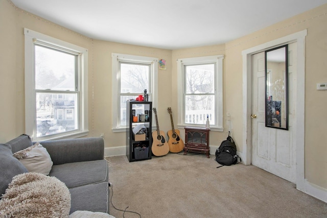 living area with light carpet and baseboards