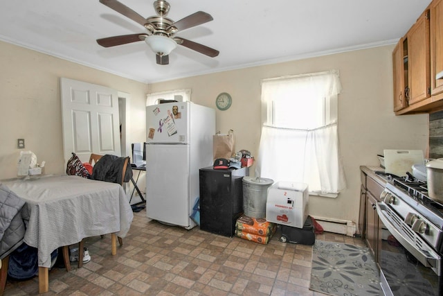 kitchen featuring brown cabinets, freestanding refrigerator, baseboard heating, crown molding, and gas stove