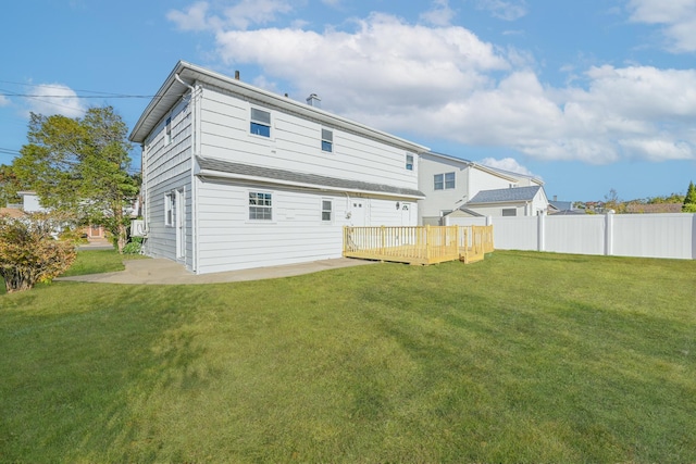 back of property featuring a wooden deck, a patio, cooling unit, and a lawn