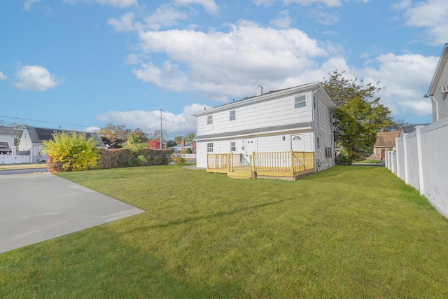 rear view of house featuring a yard and a deck