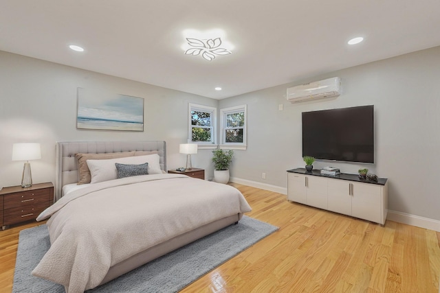 bedroom featuring an AC wall unit and light wood-type flooring