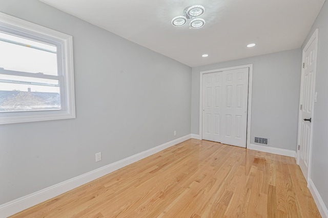 unfurnished bedroom with light hardwood / wood-style floors and a closet