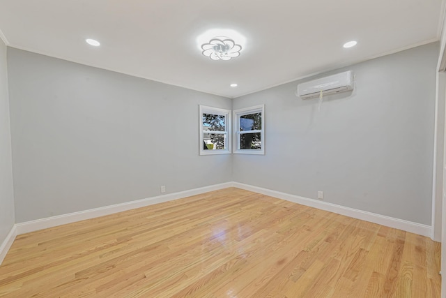 empty room featuring an AC wall unit and light hardwood / wood-style floors