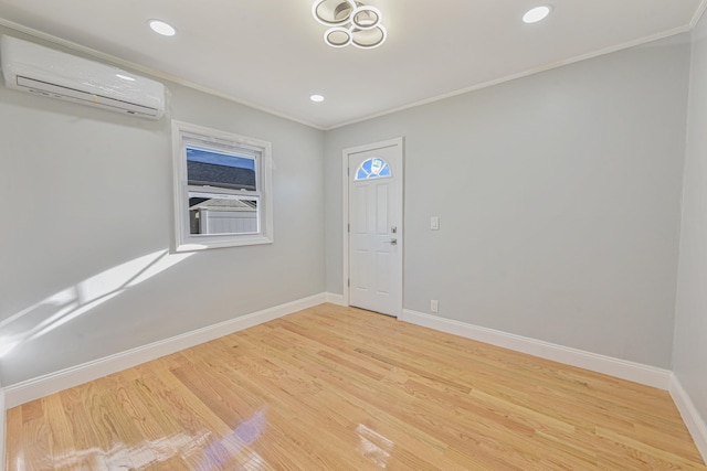 spare room featuring hardwood / wood-style floors, crown molding, and a wall mounted air conditioner