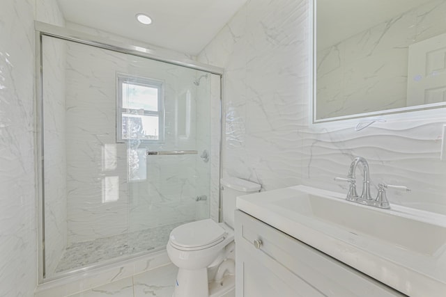 bathroom with vanity, toilet, a shower with shower door, and tile walls