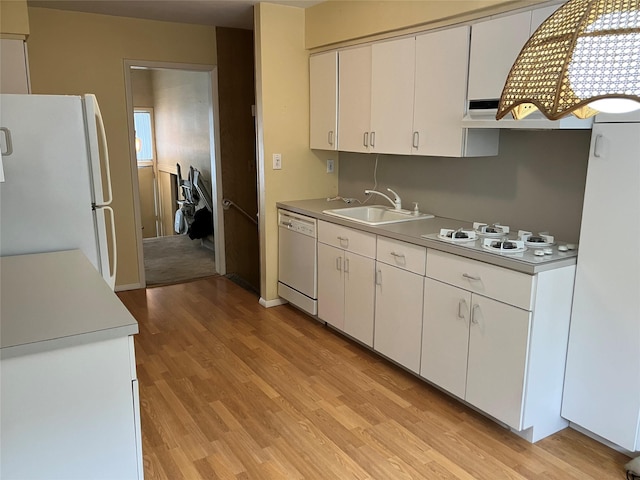 kitchen featuring premium range hood, sink, light hardwood / wood-style flooring, white appliances, and white cabinets