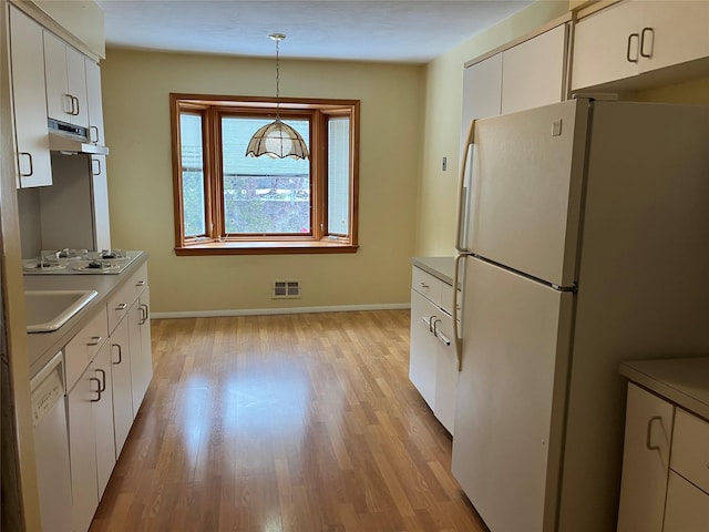 kitchen with pendant lighting, white appliances, light hardwood / wood-style floors, and white cabinets