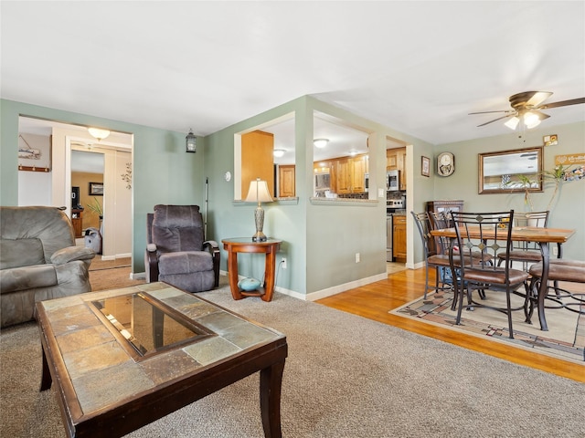 living room featuring light colored carpet and ceiling fan