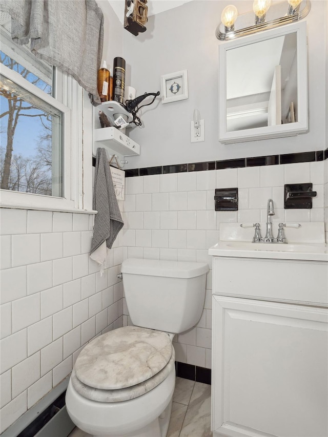 bathroom with vanity, tile walls, and toilet