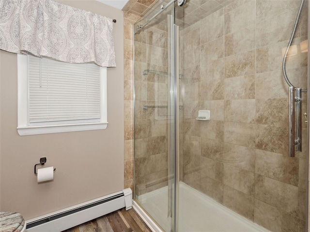 bathroom with hardwood / wood-style floors, baseboard heating, and walk in shower