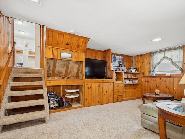 living room with carpet floors and wood walls