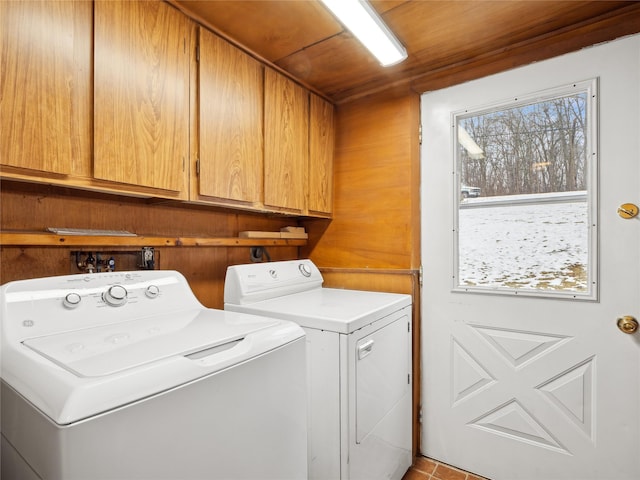 clothes washing area with wood ceiling, washer and clothes dryer, and cabinets