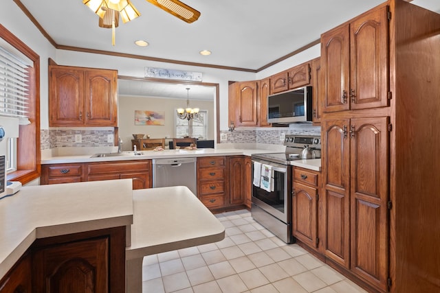 kitchen with sink, crown molding, light tile patterned floors, hanging light fixtures, and stainless steel appliances