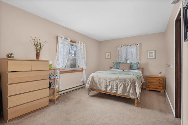 bedroom with a baseboard heating unit and light carpet