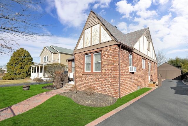 view of side of property featuring brick siding, a yard, a shingled roof, a garage, and cooling unit