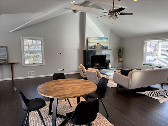 dining space with dark wood-type flooring, baseboards, and a premium fireplace