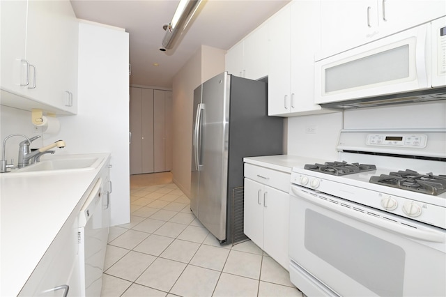 kitchen featuring white appliances, light countertops, white cabinetry, light tile patterned flooring, and a sink