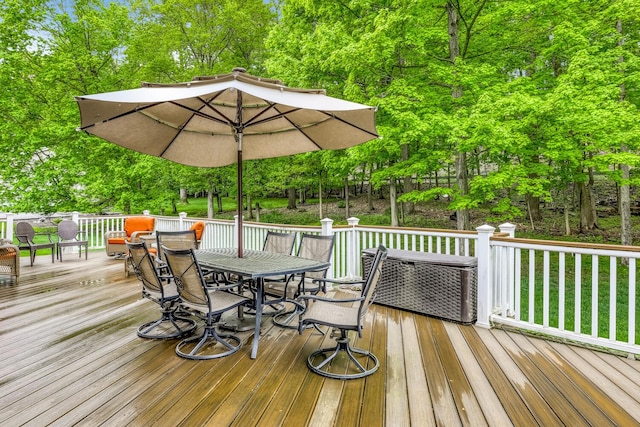 wooden deck with a yard and outdoor dining area