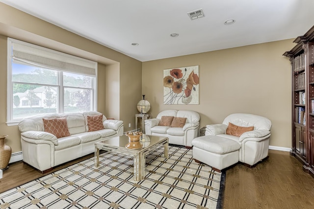 living area with recessed lighting, visible vents, baseboard heating, wood finished floors, and baseboards