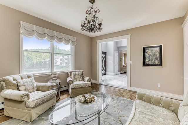 living room with a notable chandelier, a baseboard radiator, wood finished floors, and baseboards