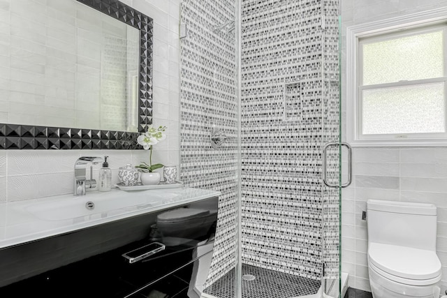 full bath with a shower stall, tile walls, toilet, and vanity