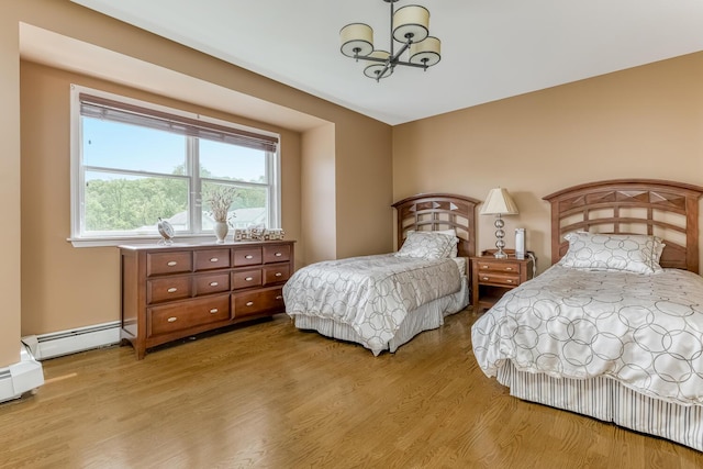 bedroom featuring a chandelier, light wood-type flooring, and a baseboard radiator