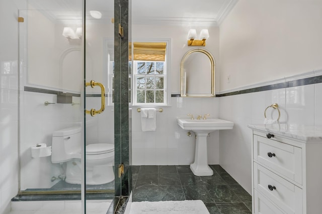 bathroom with ornamental molding, toilet, tile walls, and a shower with shower door