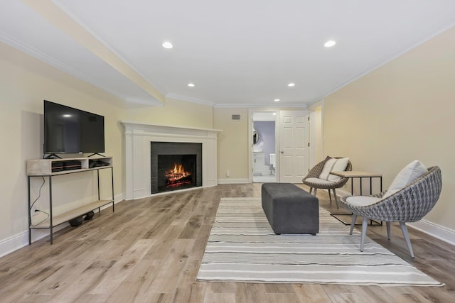 sitting room with crown molding and light hardwood / wood-style floors