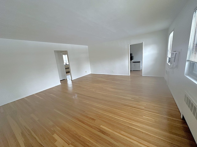 empty room with radiator heating unit and light wood-type flooring