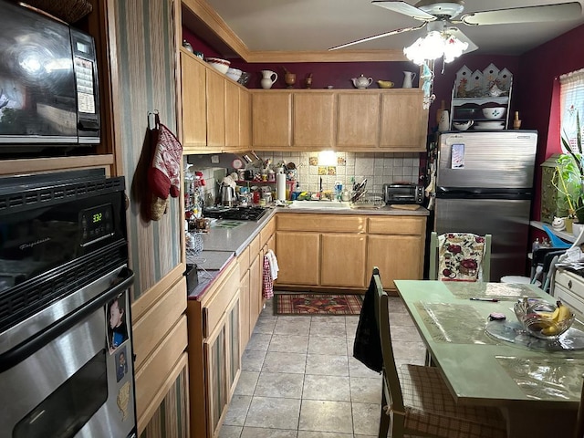 kitchen featuring appliances with stainless steel finishes, tasteful backsplash, sink, light tile patterned floors, and ceiling fan