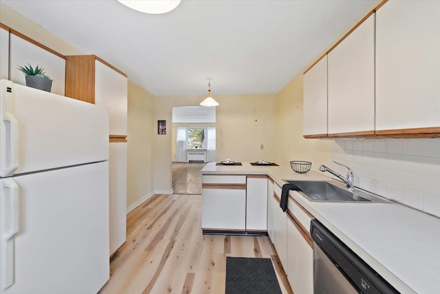 kitchen with sink, stainless steel dishwasher, white cabinets, and white fridge